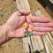 Southwestern beaded keychain with coral and turquoise beads, shown in hand to display size and detail.